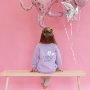 Lillafarbeneder Kinderpullover mit Blumenprint und Growing Side by Side Schriftzug
