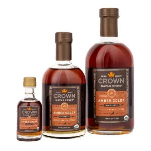 Bio-Ahornsirup von Crown Maple: Amber Color Rich Taste, Grade A, in drei Glasflaschen-Größen vor weißem Hintergrund.