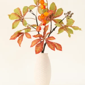 Der Kunstblumenstrauß Autumn Flair aus Seide besteht aus einer Vase mit weißer Struktur und Laternenzweig, orangefarbenen Laternenblüten und grün-roten Blättern, die vor einem schlichten hellen Hintergrund eine stilvolle Herbstdekoration bilden.