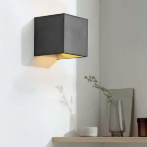 Gantlights B3 Wandlampe quadratisch Beton an weißer Wand, goldbeschichtetes Innere strahlt warmes Licht nach oben und unten