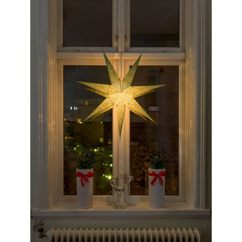 Grüner Papierstern perforiert und grün bestickt 7 Zacken ohne Leuchtmittel im Fenster, stimmungsvolle Weihnachten Dekoration.