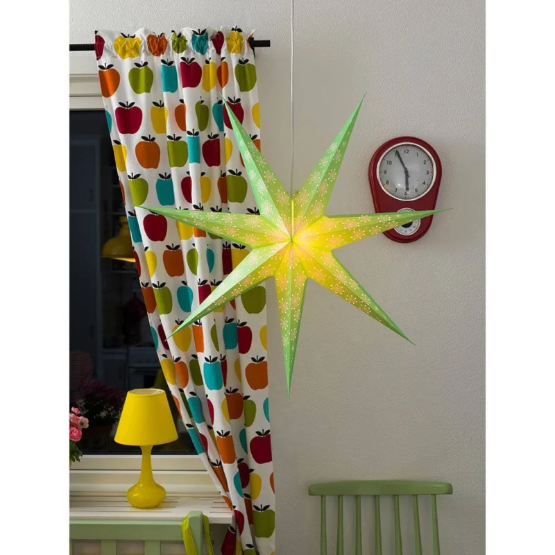 Grüner Papierstern perforiert mit weiß bedrucktem Muster 7 Zacken ohne Leuchmittel im Fenster dekoriert.