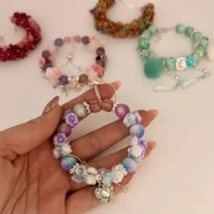 Hand hält buntes Soft Flower Armband mit Blumen-Perlen als stylisches DIY-Schmuck Geschenk von Picmondoo