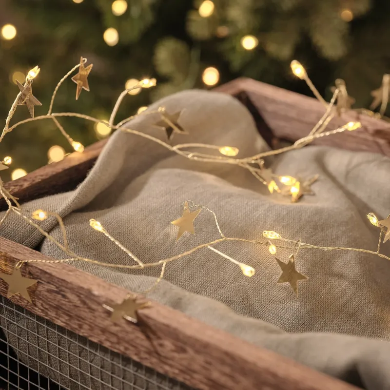 1,5m LED-Sternenlichterkette in Gold mit 50 Mikro-LEDs beleuchtet dekoriert auf einem weihnachtlichen Korb