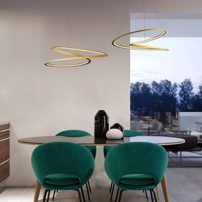 Nemo LED-Hängeleuchte Kepler Petite über einem modernen Esstisch mit bunten Stühlen.