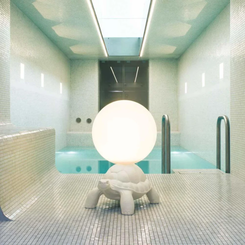 Turtle Carry LED Akku Leuchte IP55 in einem modernen Innenraum mit Pool.