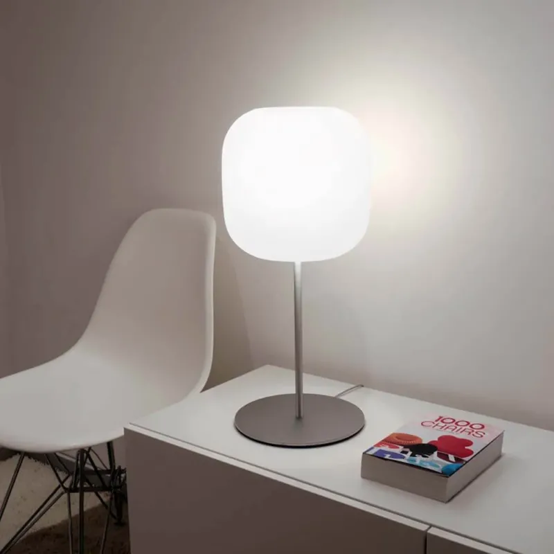 Casablanca Tischleuchte Murea Ø 25cm Alu auf einem modernen Sideboard neben einem weißen Stuhl