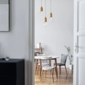 Veda Pendelleuchte G9 3-flammig Ø 30cm über einem eleganten Essbereich in modernem Design.