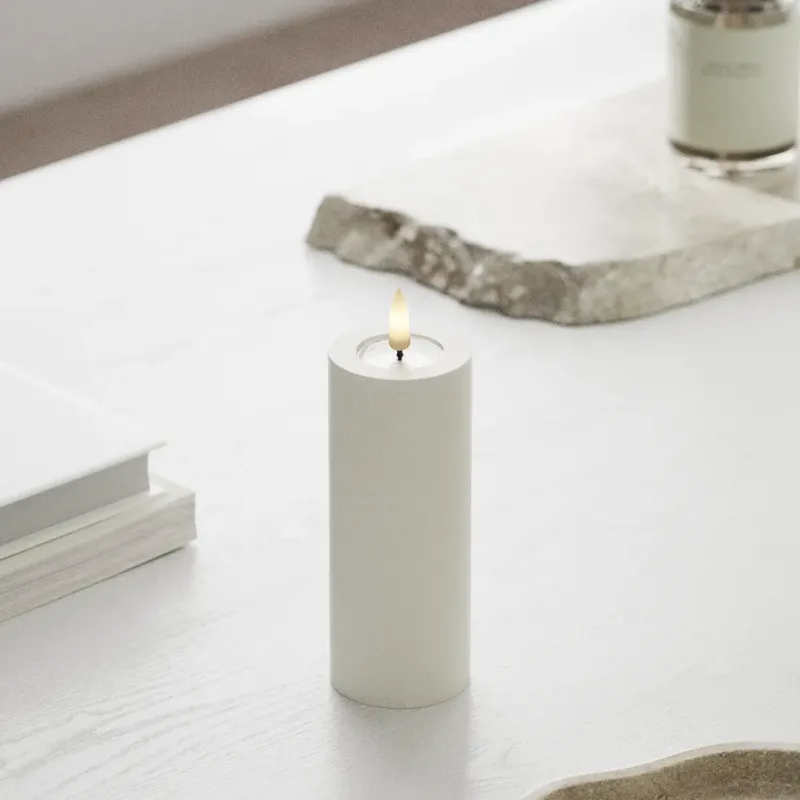 Weiße LED Kerze mit Echtwachs und realistischer 3D-Flamme auf weißem Tisch, Nordicflame