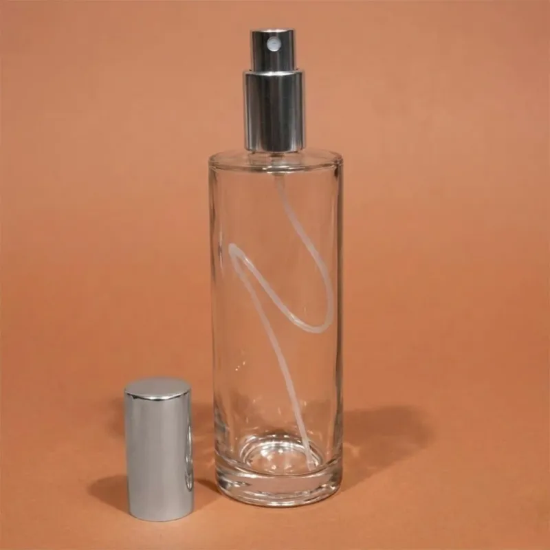 Flacon Classic haut en verre transparent, atomiseur et capot argentés posés à côté