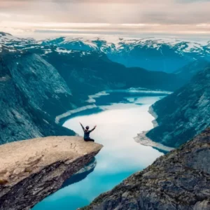 Person Standing On Cliff Overlooking Lake