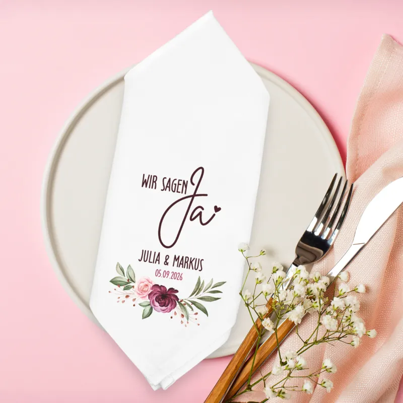Personalisierte Stoffserviette Hochzeit Wir sagen Ja mit Blumenmotiv Namen und Datum auf Teller dekoriert