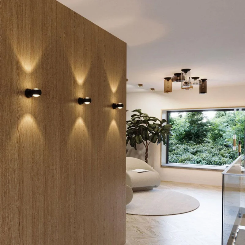 s.luce Beam Wandleuchte Up&Down mit Linsen in modernem Wohnraum mit Holzpaneelen.