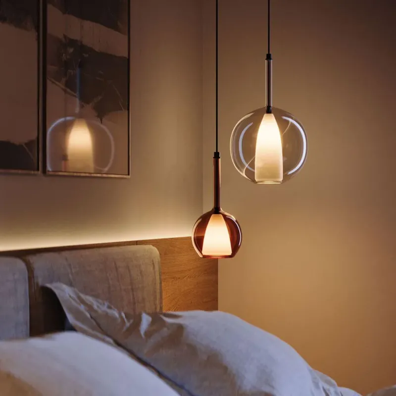 s.luce Belluna Glas-Pendelleuchte 150cm Textilkabel in elegantem Schlafzimmer mit Holzbettrahmen.
