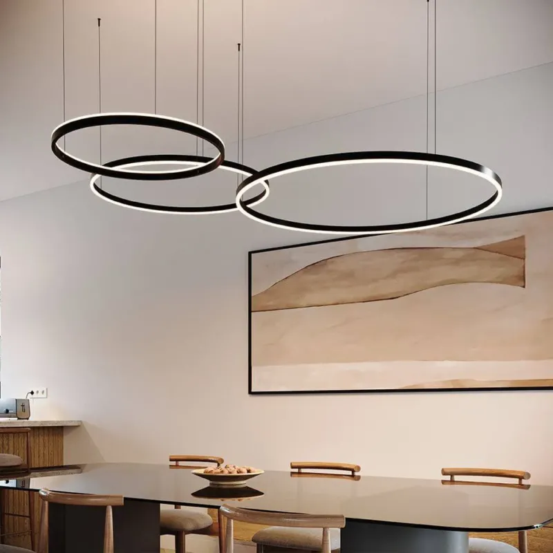 s.luce LED Ring Pendelleuchte 3-flammig Exzentrisch über einem Esszimmer-Tisch mit modernem Design.